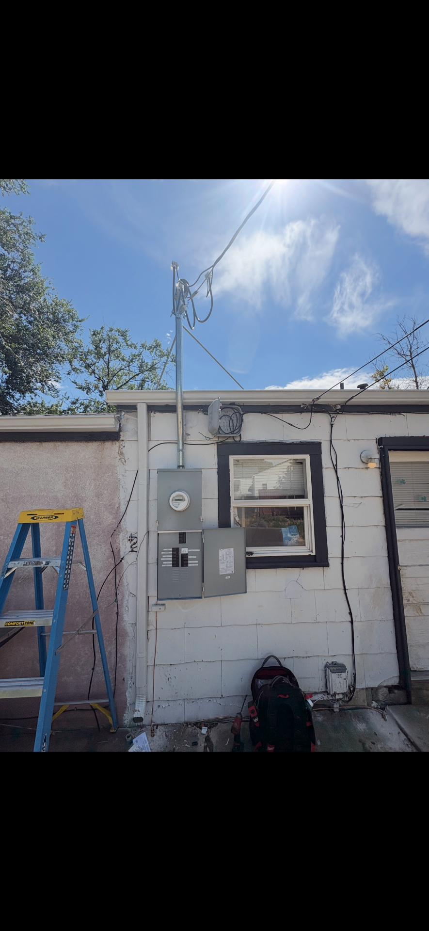 Meter, main panel and service mast installed on an exterior wall
