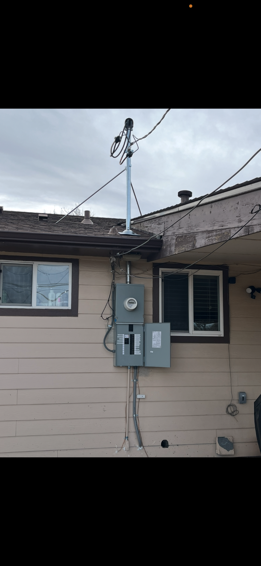 New service mast, meter and main panel installed on a home exterior