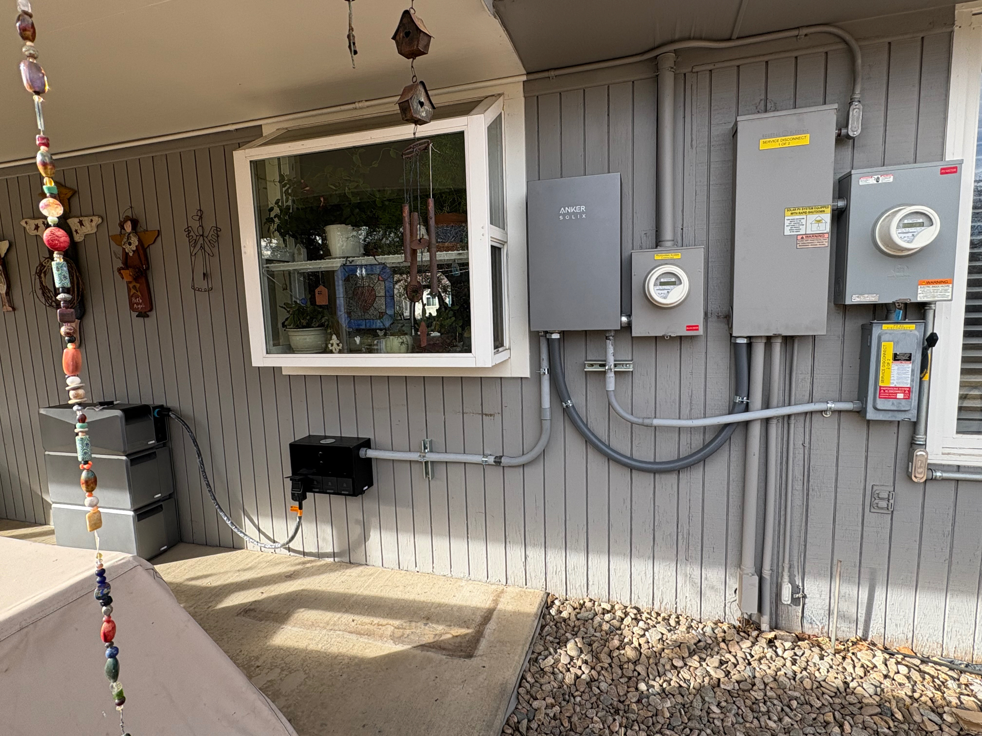 Exterior Anker SOLIX battery system with production meter, service disconnects and meter main