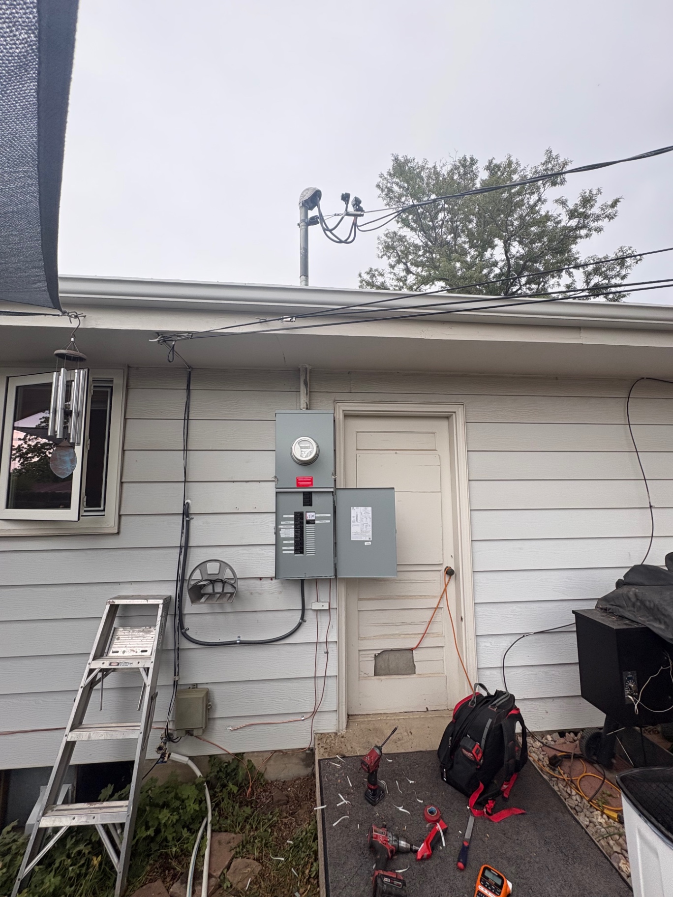 Finished meter, main disconnect and sub-panel on a home with gray siding