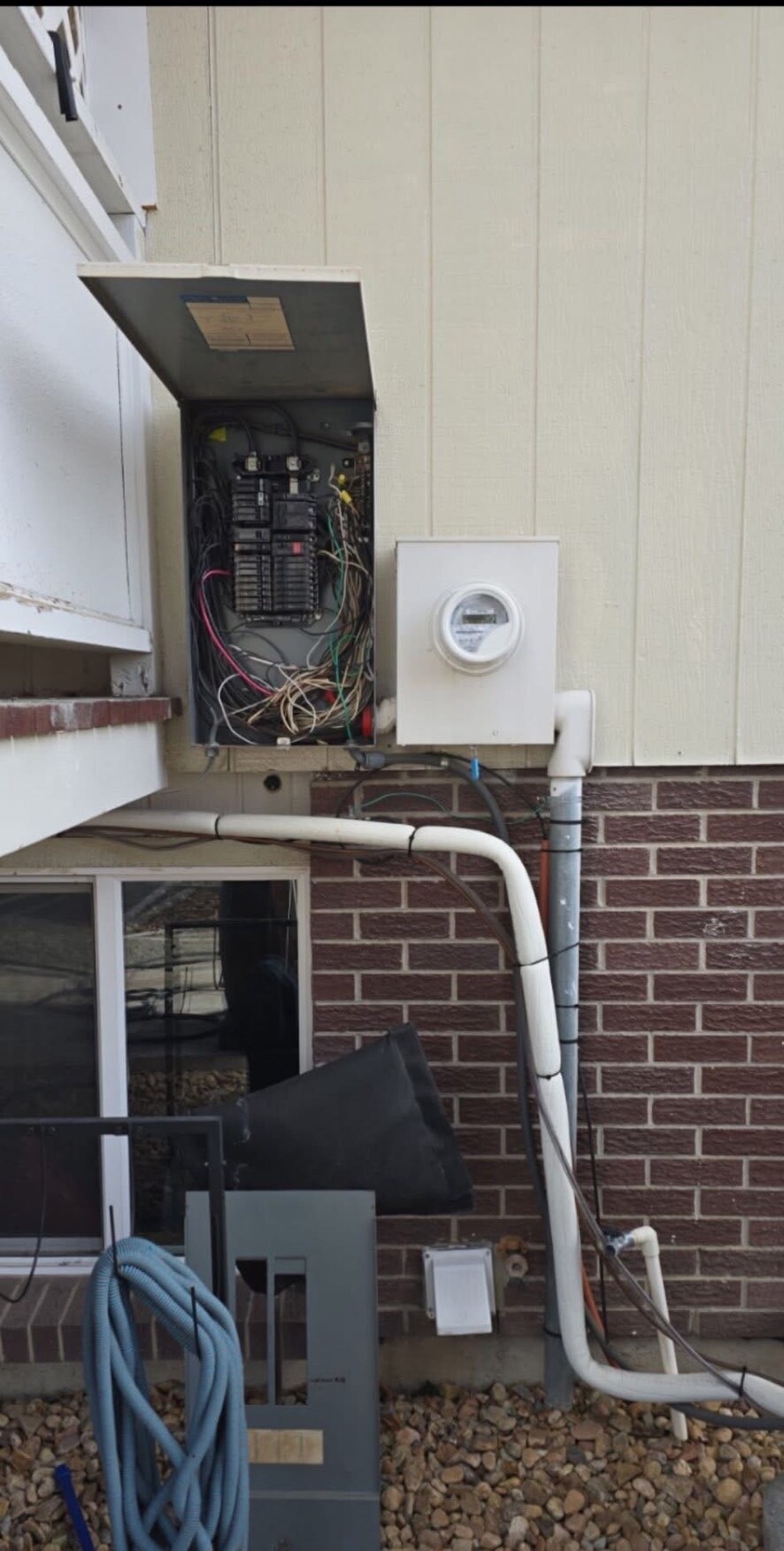 Before: aging exterior panel with cloth-wrapped wiring and an old meter socket